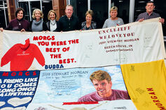 A group holds up a banner honoring Jeff S. Morgan.